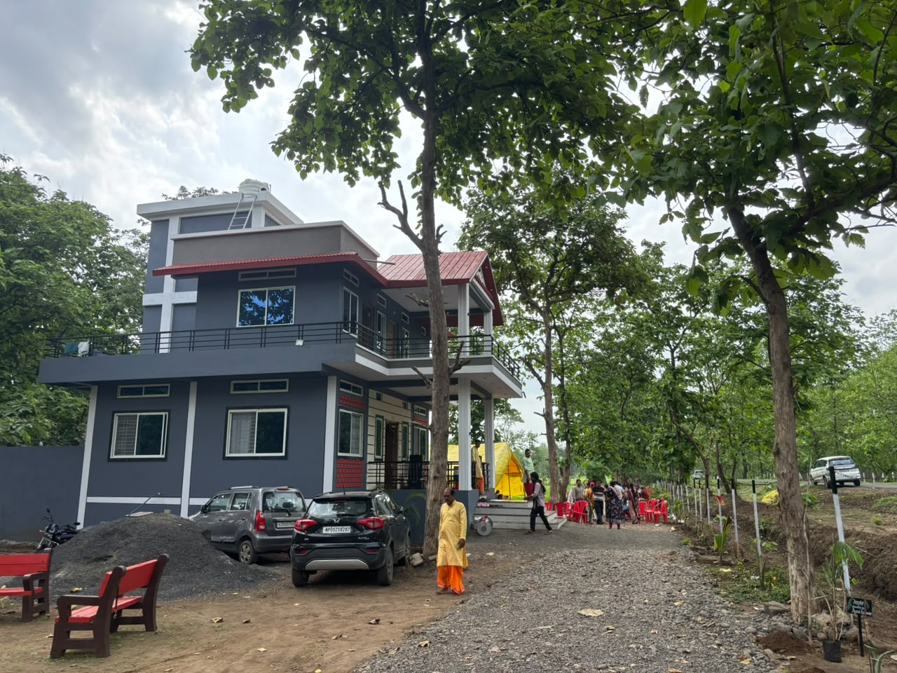 The farmhouse seen from the tree-lined gravel drive